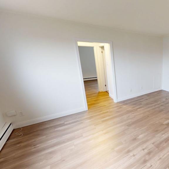 a room with wooden flooring and a doorway leading to another room.