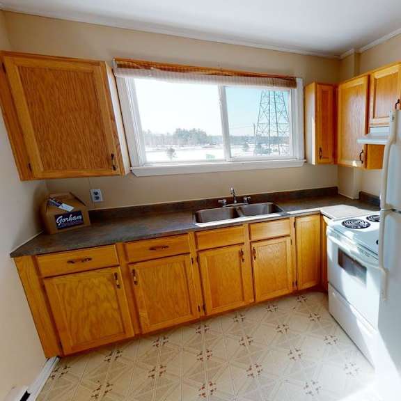 a kitchen with wooden cabinets and a white fridge.
