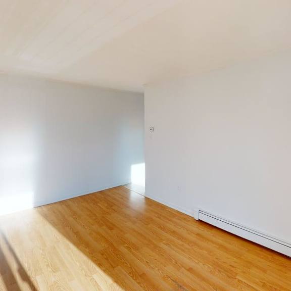 a room with wooden flooring and white walls.