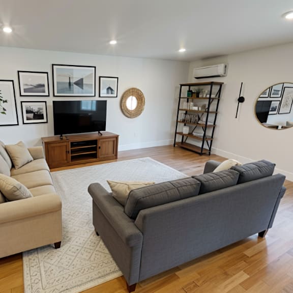a living room with a grey couch and a beige armchair.