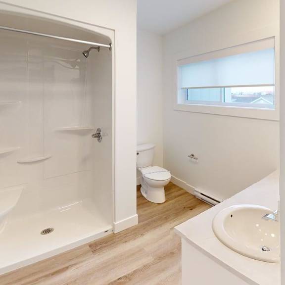 a white bathroom with a walk-in shower and toilet.