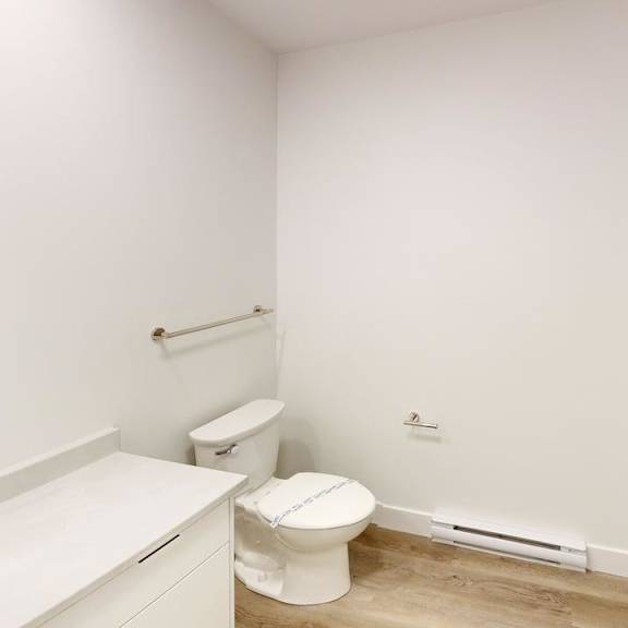 a white bathroom with a toilet, sink, and bathtub.