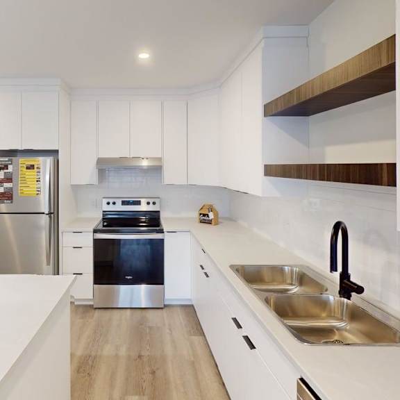 a modern kitchen with white cabinets and a stainless steel refrigerator.