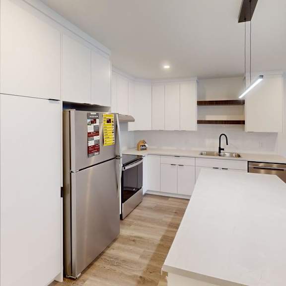 a modern kitchen with white cabinets and a stainless steel refrigerator.