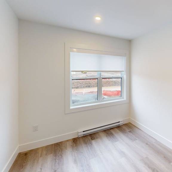 a room with a window and a wooden floor.
