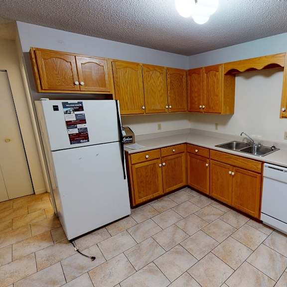 a kitchen with wooden cabinets and white appliances.