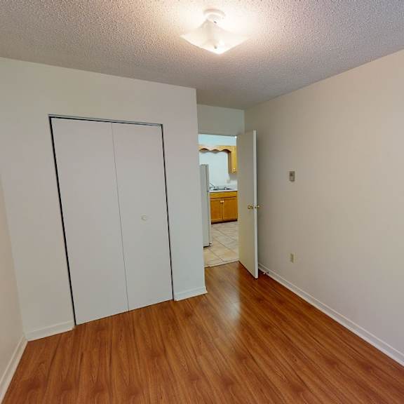 a room with a white door and a wooden floor.