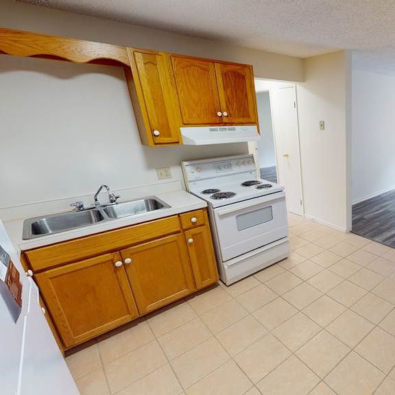 a kitchen with wooden cabinets and a white stove top oven.