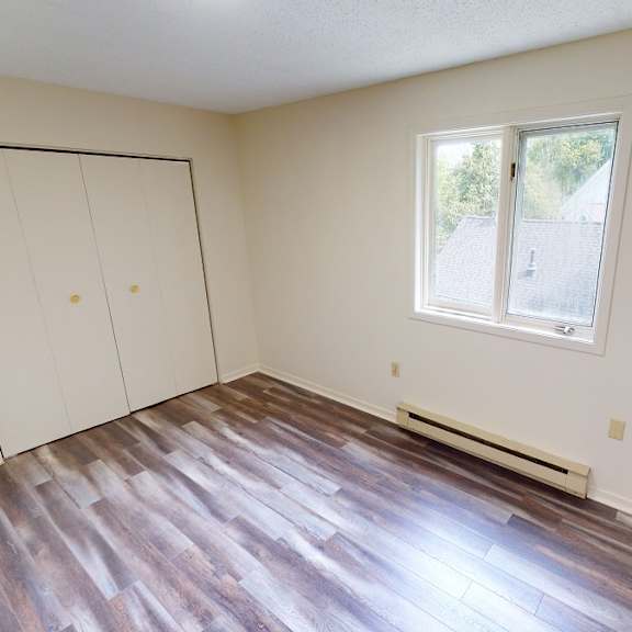 a room with a window and a wood floor.