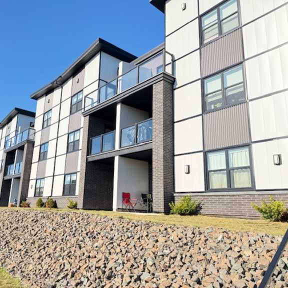 a modern building with a stone wall in front.