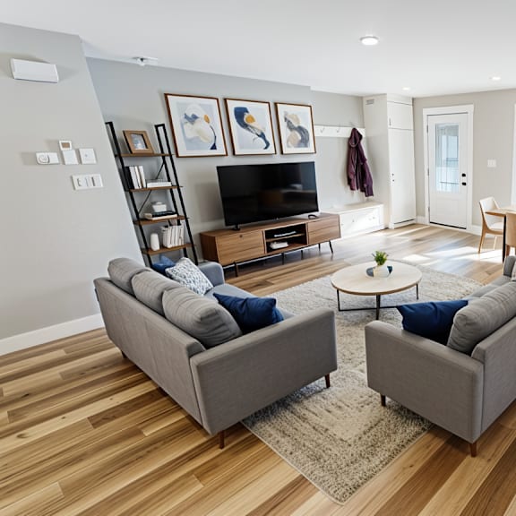 a living room with a grey couch and a wooden floor.