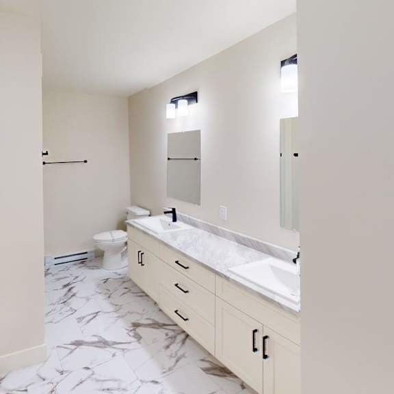 a bathroom with a marble floor and white walls.