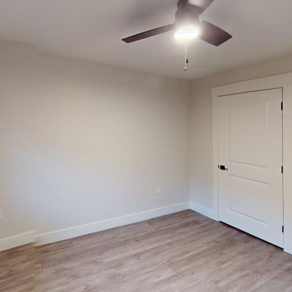 a room with a ceiling fan and a door.