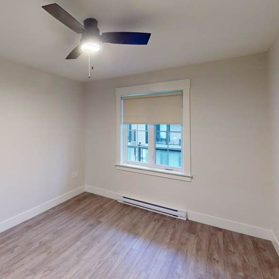 a room with a window and a ceiling fan.