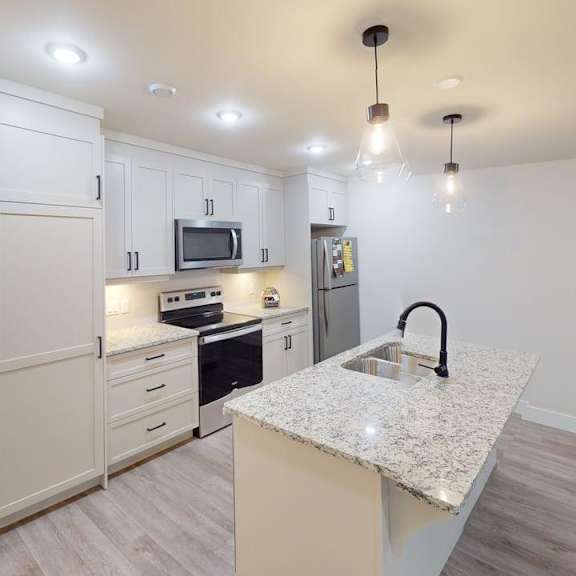 a kitchen with a granite countertop and a microwave above it.
