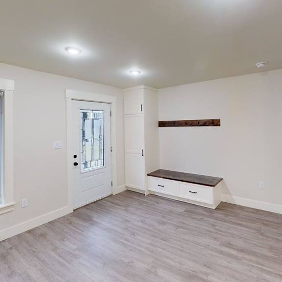 a room with a window, a door, and a bench.