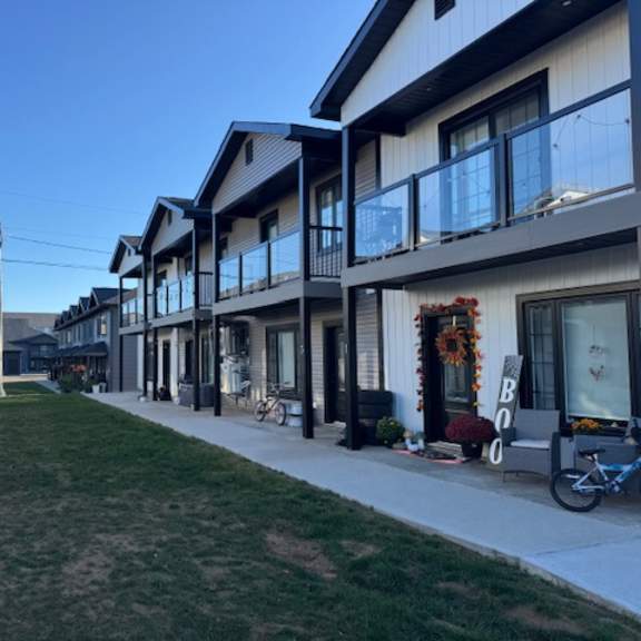 a row of modern houses with a bicycle parked in front of one.