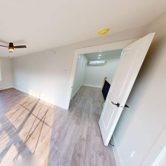 a room with a sliding glass door and a ceiling fan.