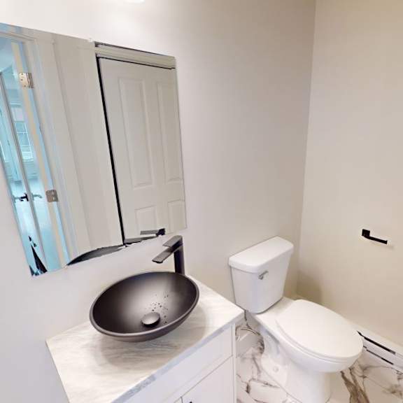 a bathroom with a toilet, sink and mirror.