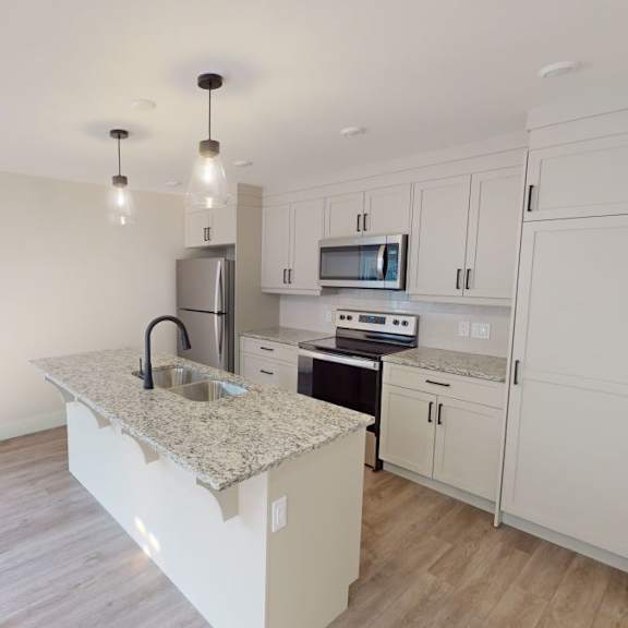 a kitchen with white cabinets and a granite countertop.