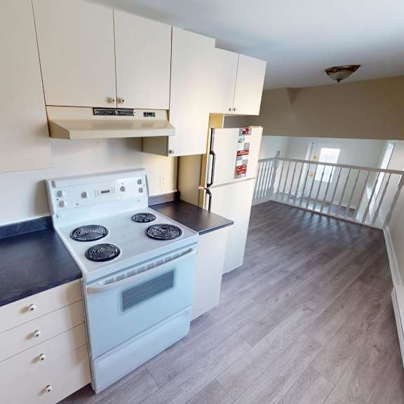 a kitchen with a stove top oven and a refrigerator.