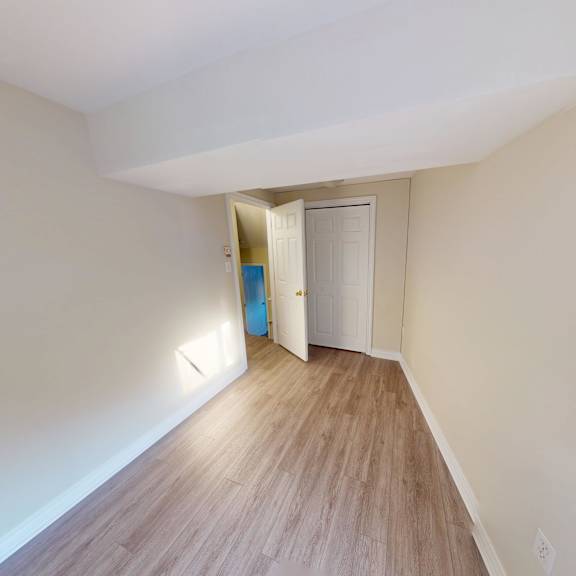 a hallway with a wooden floor and white walls.
