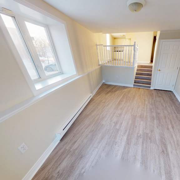 a room with wooden flooring and white walls.