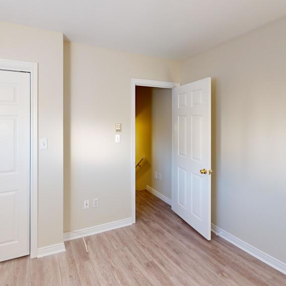 a room with a white door and a white wall with a switch.