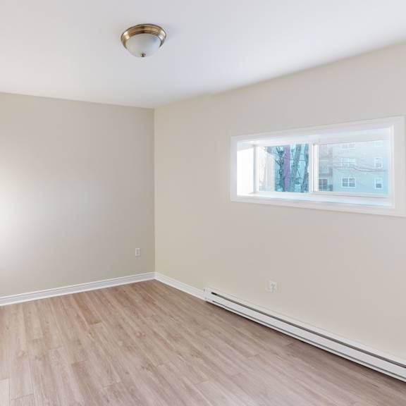 a room with a window and a wooden floor.