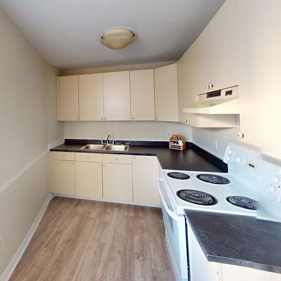 a kitchen with a white stove top oven and white cabinets.