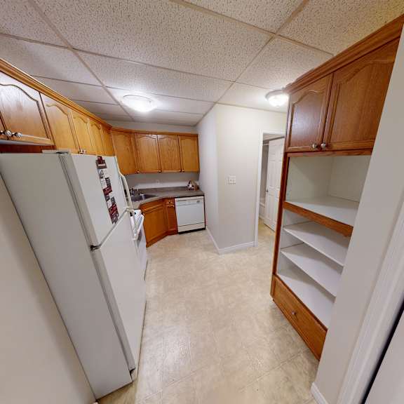 a kitchen with white appliances and wooden cabinets.