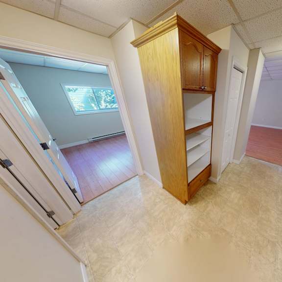 a small room with a wooden cabinet and a skylight.