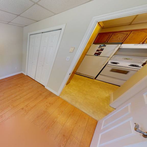 a room with wooden flooring and a white door.