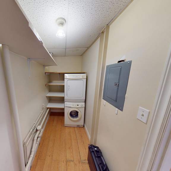 a white fridge and dishwasher in a narrow hallway.