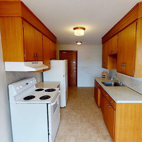 a kitchen with white appliances and wooden cabinets.