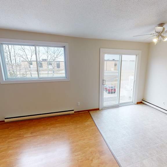 a room with a window and a door leading to a hallway.