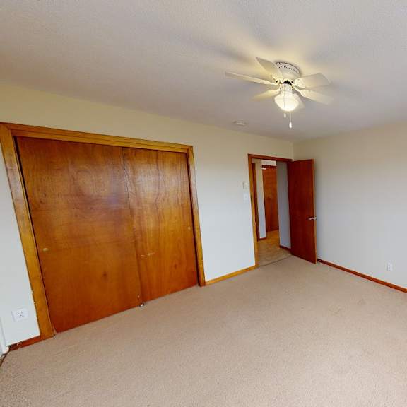 a room with a ceiling fan and a window.
