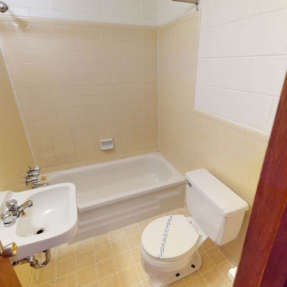 a white toilet sits next to a white sink in a small bathroom.
