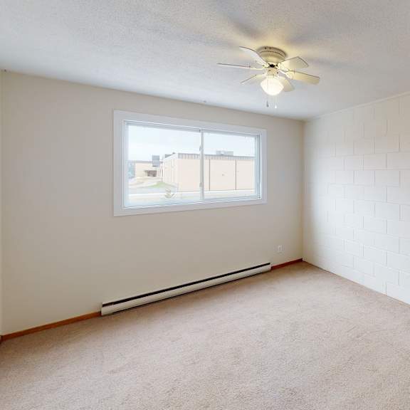 a room with a window and a ceiling fan.