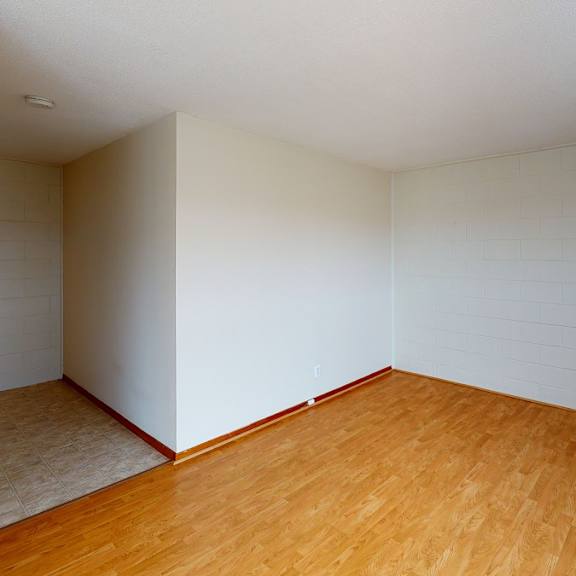 a room with wooden flooring and white walls.