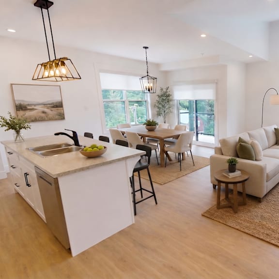 a modern living room with a kitchen area in the background.