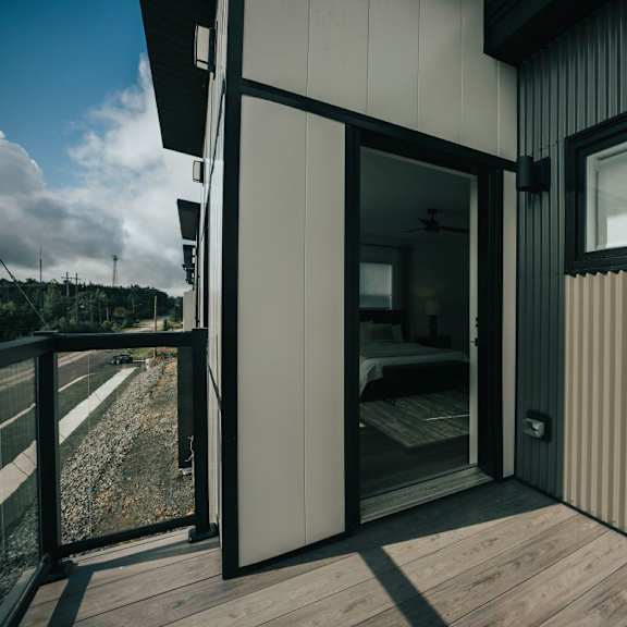 a modern house with a balcony and sliding glass doors.