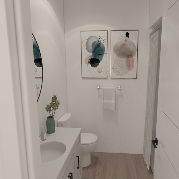 a white bathroom with a toilet, sink, and two wall hangings.
