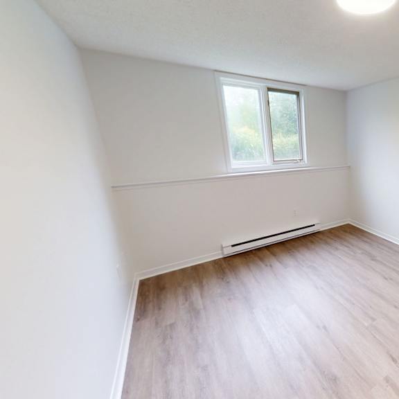 a room with a window and a wooden floor.