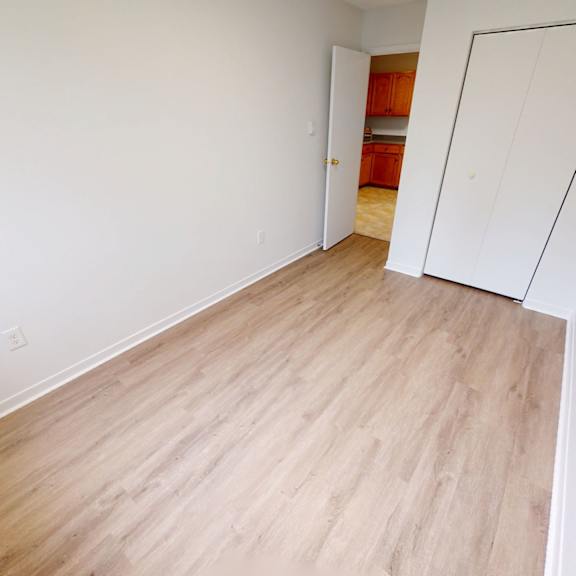a room with a white wall and a wooden floor.
