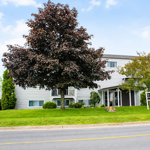 a grey building with a tree in front of it.