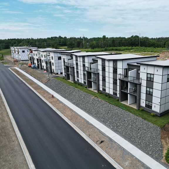 a row of modern houses are lined up along a road.
