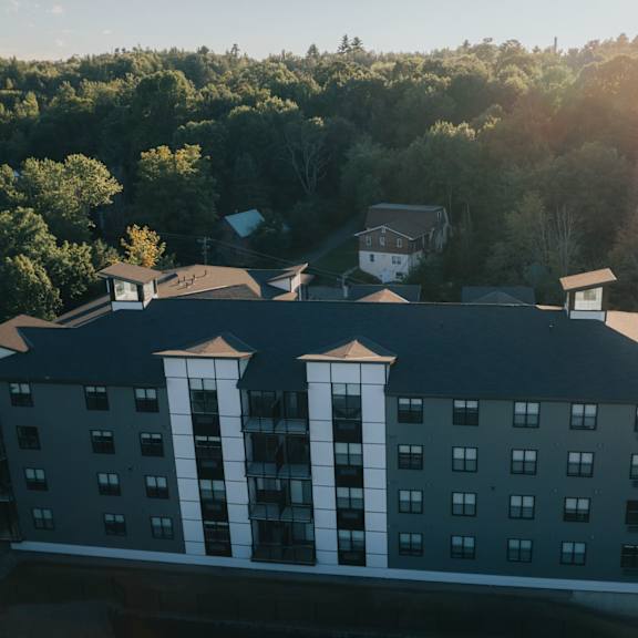 a hotel building with a sun flare in the background.