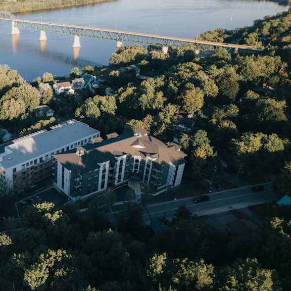 a bridge spans a river in a city with a large building in the foreground.