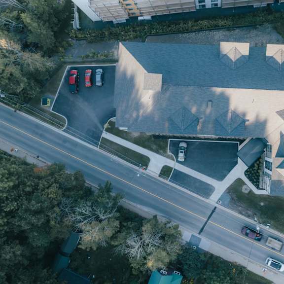 an aerial view of a road with cars and a building with a unique design.
